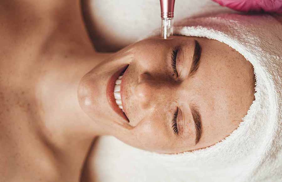 Mujer aplicando tratamiento de mesoterapia en la cara