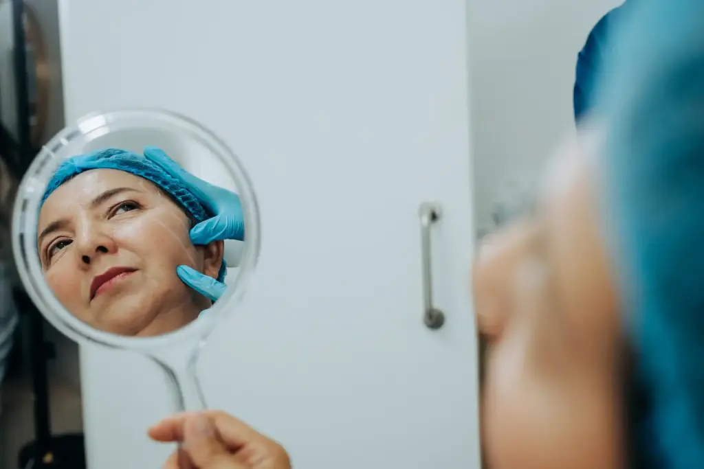 Mujer mirándose al espejo con inductores de colágeno